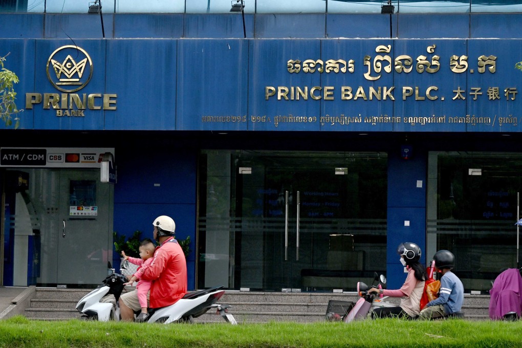 Motorists ride past a branch of Prince Bank in Phnom Penh on October 15. Hong Kong has joined jurisdictions like the United States, Britain and Singapore in freezing assets linked to China-born businessman Chen Zhi and Prince Group, a multinational network accused of running vast scam centre operations. Photo: AFP