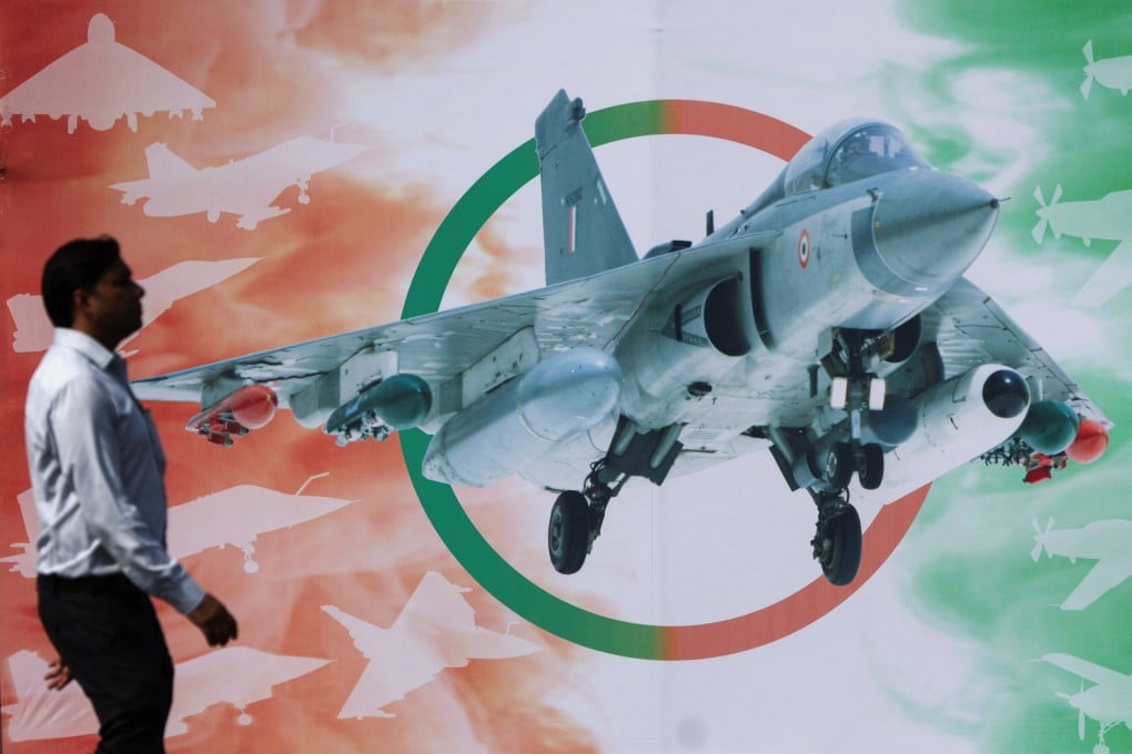 A man walks past a poster of Hindustan Aeronautics Limited’s Tejas Mark 1A light combat aircraft ahead of its maiden flight at HAL in Nashik, India, on October 17. Photo: Reuters