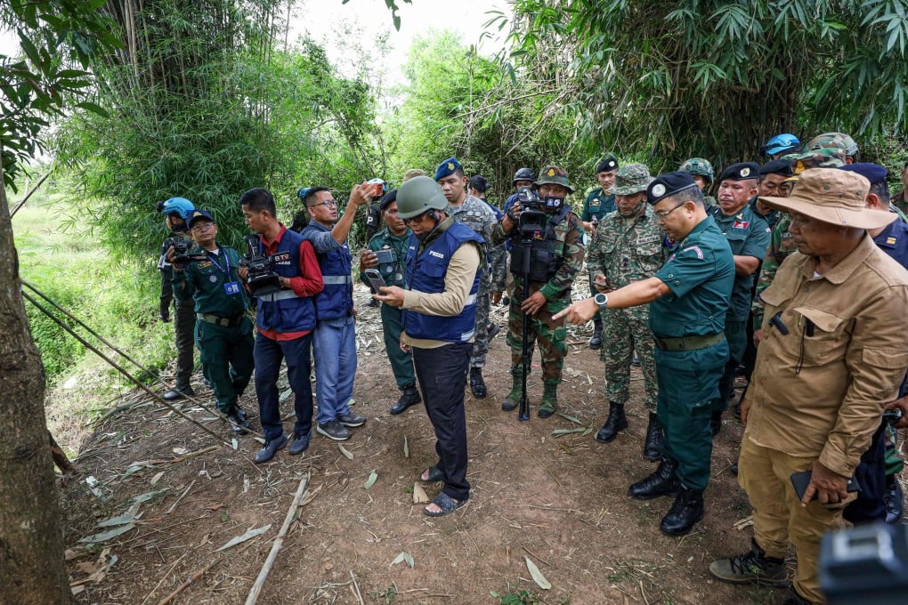 A delegation from the Asean Observer Team visits an area where a civilian was killed a day earlier along the Cambodia-Thailand border in Banteay Meanchey province. Photo: AFP /Agence Kampuchea Press