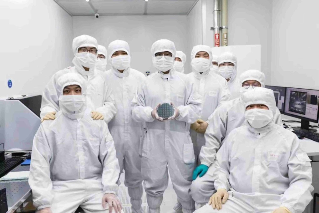 Researchers at CHIPX pose for a photo with their high-performance 6-inch thin-film lithium niobate chip, an advance that is poised to accelerate progress in AI and quantum computing.  Photo: Handout
