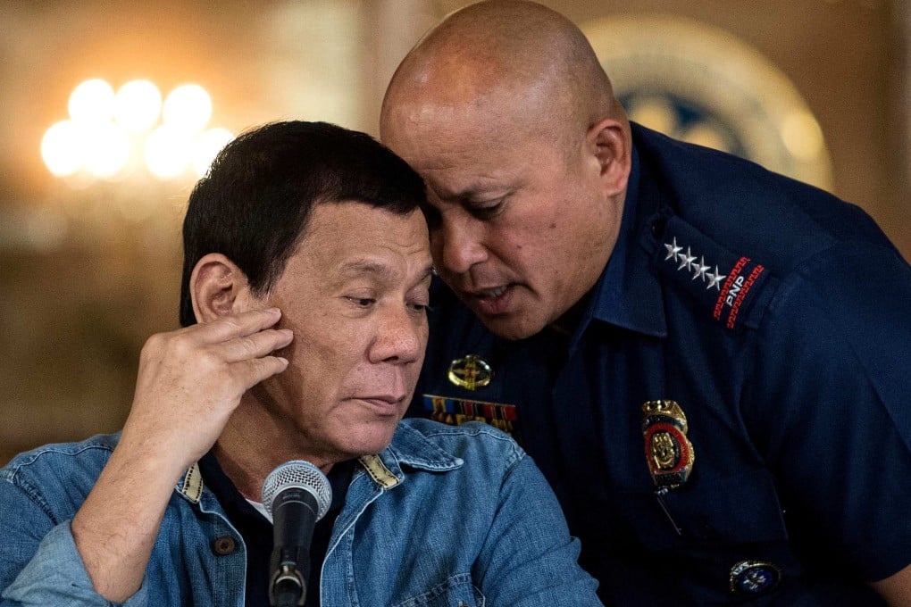 Ronald Dela Rosa (right) whispers in Rodrigo Duterte’s ear during a press conference at the Malacanang palace in Manila on January 30, 2017. Photo: AFP