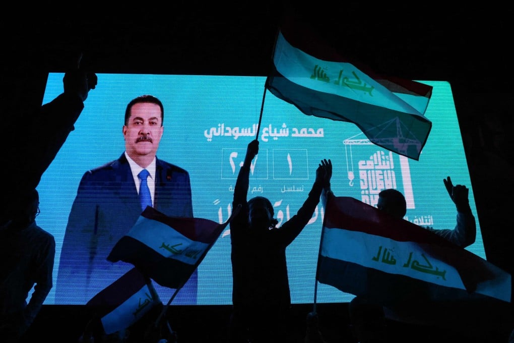 Supporters of incumbent Iraqi Prime Minister Mohammed Shia al-Sudani wave flags in front of a screen displaying his portrait as they celebrate in Baghdad on Wednesday. Photo: AFP