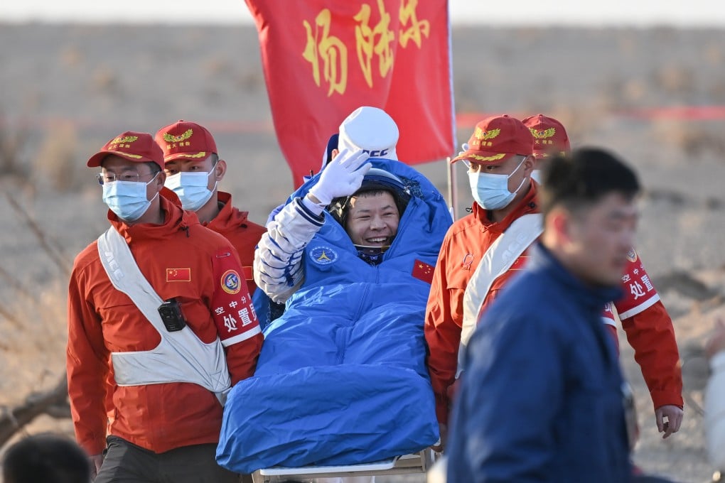 Chinese astronaut Wang Jie waves while being carried from the Shenzhou-21 spaceship’s return capsule after it touched down at the Dongfeng landing site on Friday. Photo: Xinhua