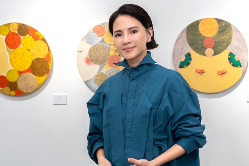 Angelica Lee Sinje stands before some of her paintings featured in Childtopia, her first Hong Kong solo exhibition, at 13a New Street Art Gallery in Sheung Wan. Photo: 13A New Street Art Gallery