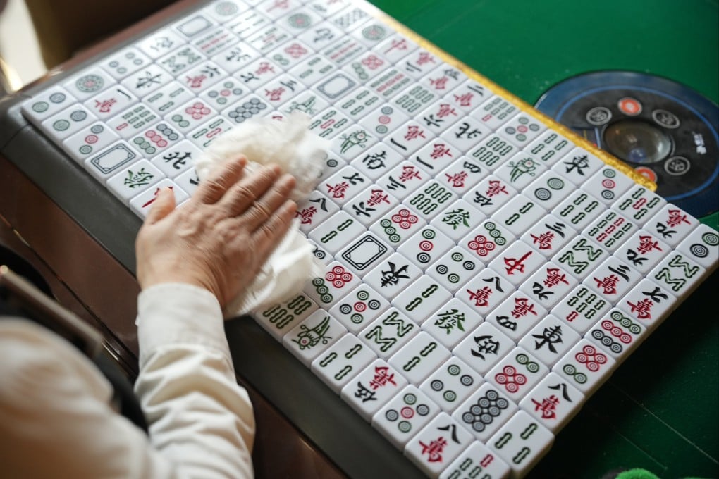 A staff member of a mahjong parlour in Hong Kong cleans the tiles. More mahjong parlours could be established, not as gambling dens but as health facilities for the elderly. Photo: May Tse
