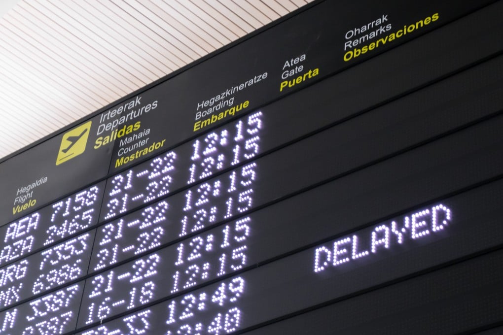 A timetable information panel shows a delayed flight at Bilbao Airport. The EU, Canada, Brazil, and Britain have airline compensation rules, but no major US airline offers cash for significant delays. Photo: Shutterstock