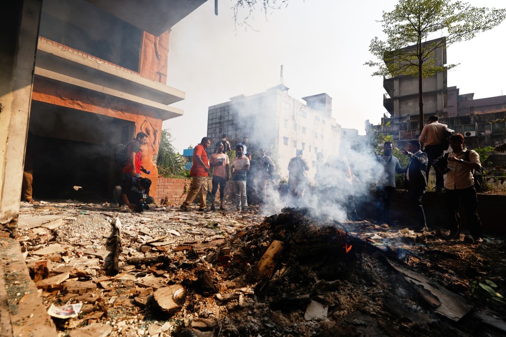 A fire smoulders after the party office of the Awami League party led by ousted prime minister Sheikh Hasina was vandalised during a nationwide “lockdown” in protest against her trial, in Dhaka, Bangladesh, on Thursday. Photo: AP