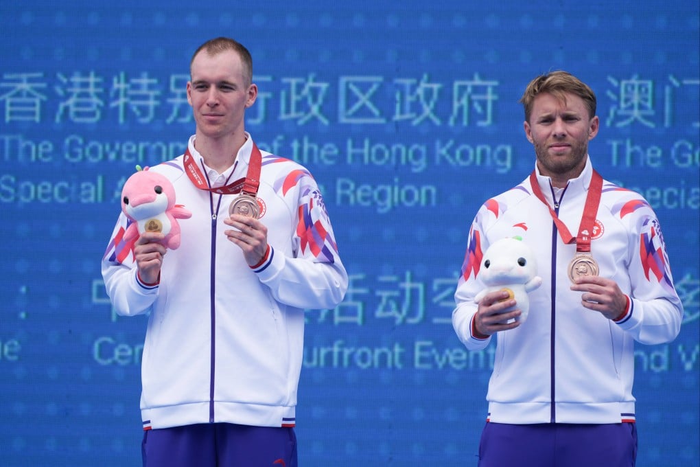 Oscar Coggins (left) and coach Andrew Wright on the triathlon podium after Saturday’s individual race. Photo: Eugene Lee