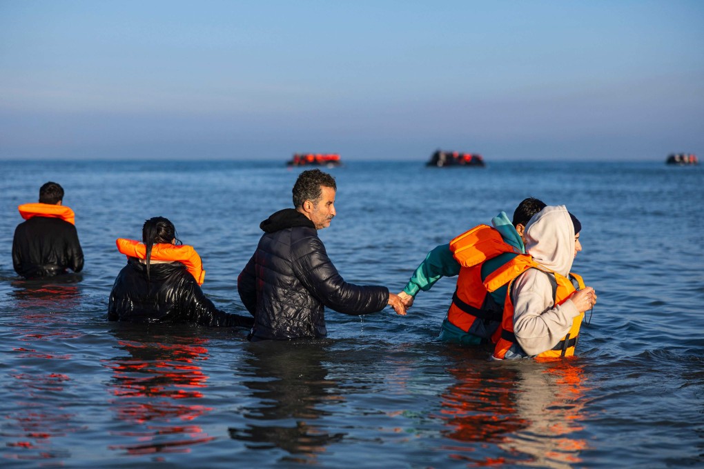 Migrants wade into the sea to try to board smugglers’ boats and cross the English Channel from France into Britain in September. Photo: AFP