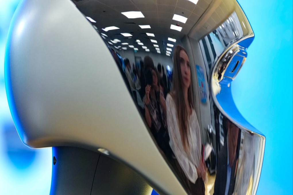 Visitors to the AI and Robotics Fest at the Hong Kong Productivity Council building in Kowloon Tong are reflected on the head of a humanoid robot, on November 10. Photo: Karma Lo