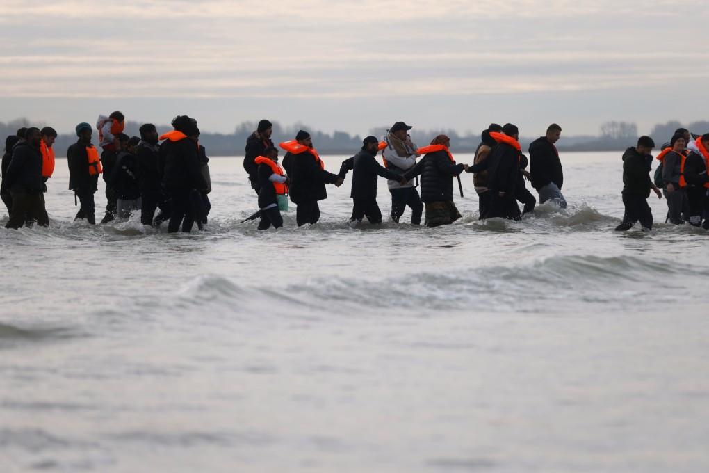 Migrants in Gravelines, northern France, walk in the water to board a small boat in an attempt to reach Britain. Photo: AP