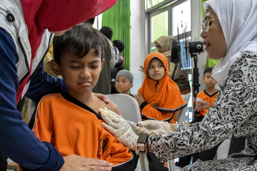 A healthcare worker administers a measles vaccine to a junior school student in Jakarta on August 4. Photo: AFP