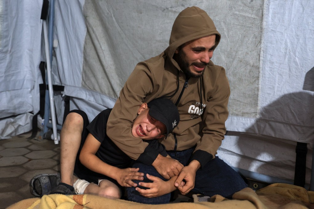 A man and a child mourn at Al-Ahli Arab Hospital in Gaza City on Wednesday, after a deadly Israeli strike. Photo: Reuters