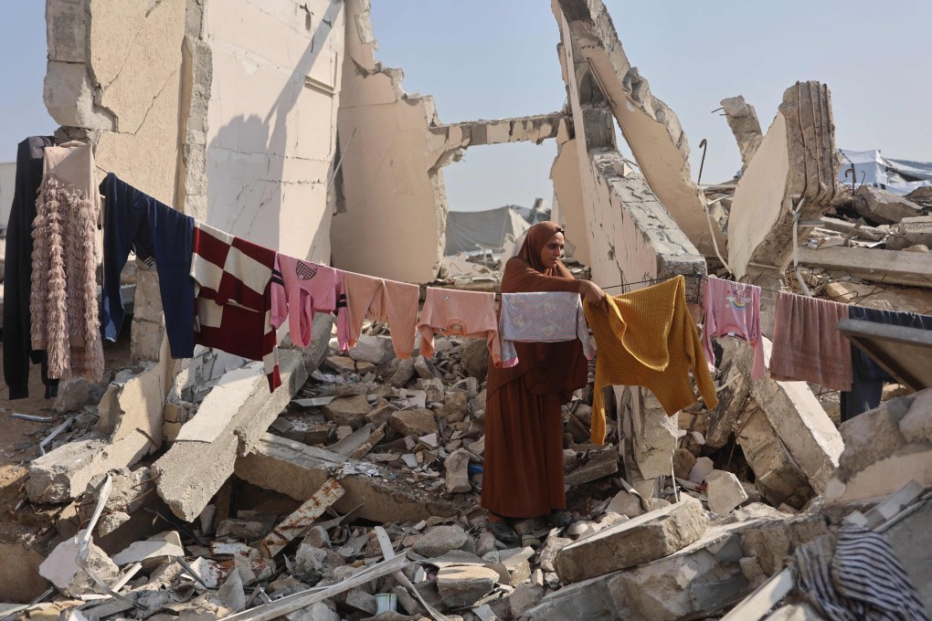 A Palestinian woman hangs clothes to dry amid the ruins of a building in Gaza City on November 18. Photo: AFP