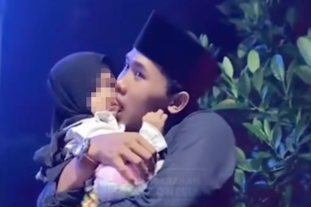 Islamic cleric Mohammad Elham Yahya Al Maliki is seen embracing a young girl and sucking in her cheeks. Other clips show him kissing several children on the cheek. Photo: YouTube/Gerakanpis