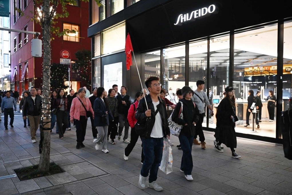 A Chinese tour group walks past a Shiseido store in Tokyo on November 17, 2025. Photo: AFP