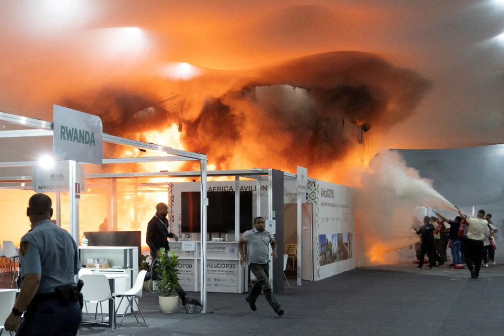 People use fire extinguishers to put out a fire at the Pavilion of Countries in the Blue Zone. Photo: Reuters