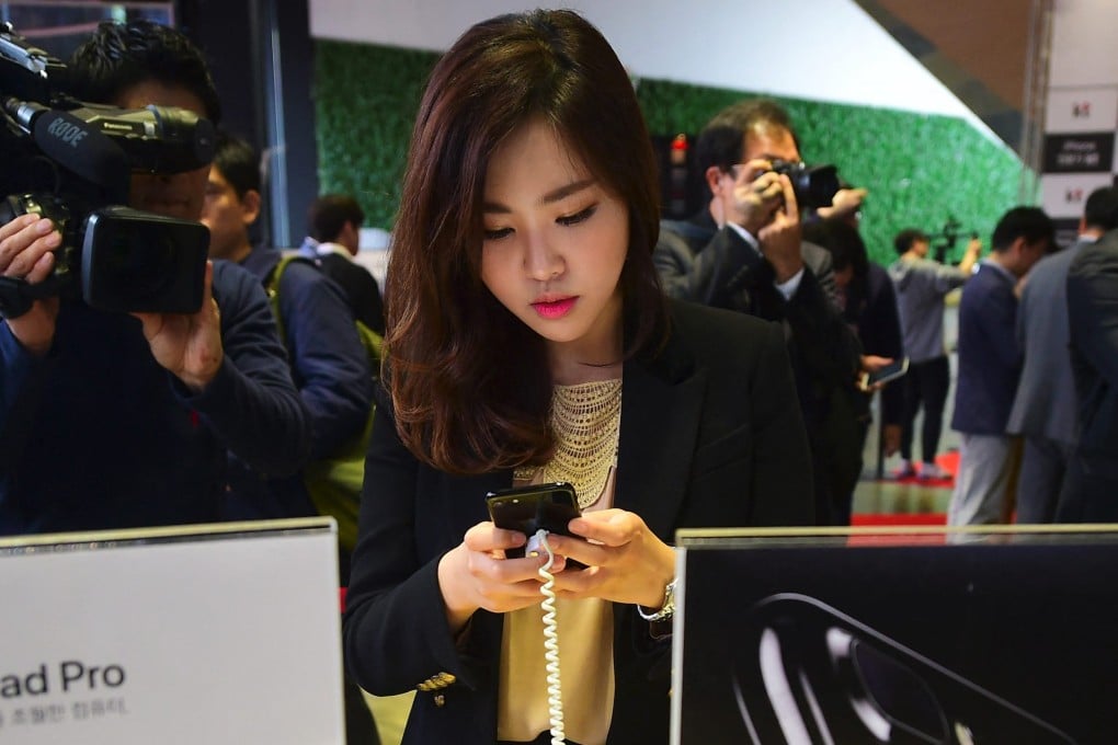 A woman looks at an Apple iPhone at a shop in Seoul. Photo: AFP