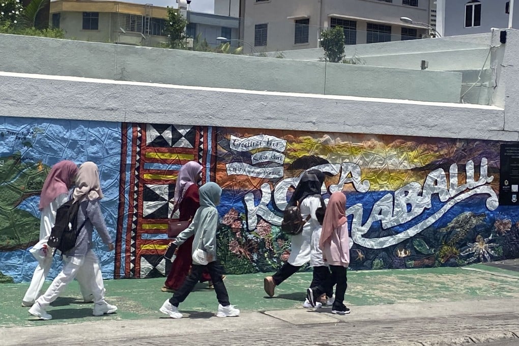 Young Malaysians walk along a street in Kota Kinabalu, Sabah, Malaysia. Photo: Tamara Hinson