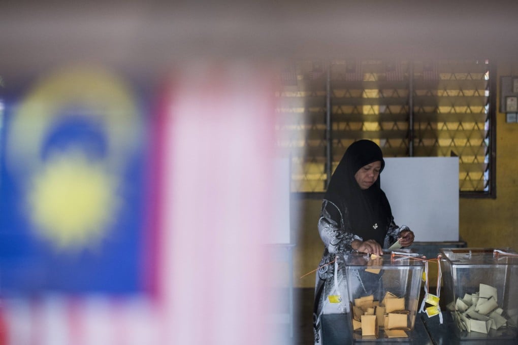 A woman casts her ballot at a polling station during a previous election in Malaysia. Photo: AFP
