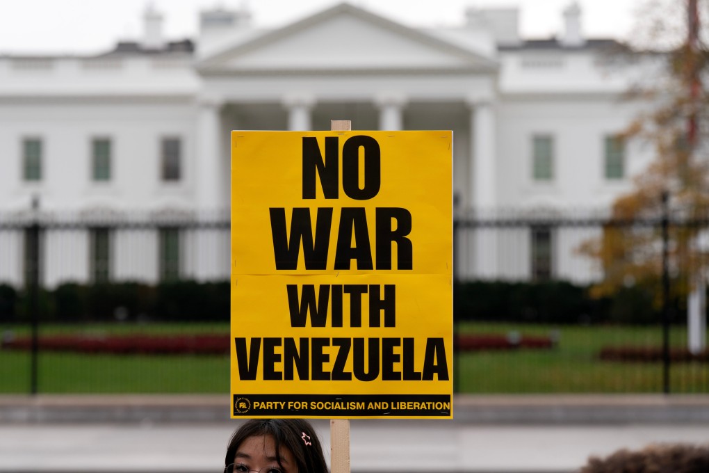 A demonstrator holds a “No War With Venezuela” sign while protesting outside the White House in Washington, on November 15. Photo: AP