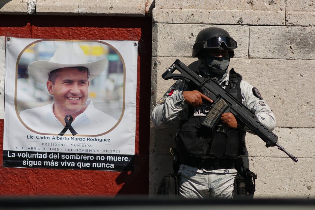 A National Guards officer stands next to a portrait of slain Mayor Carlos Manzo Rodriguez on Friday in Uruapan, Mexico, as prosecutors detain suspects in the investigation into his killing. Photo: AP
