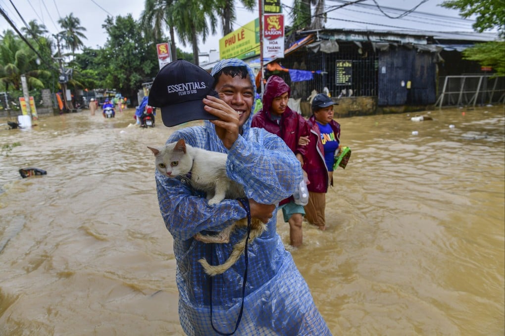 A man carrying his cat wades through flood water in Nha Trang, Khanh Hoa province, Vietnam, on Friday. Photo: EPA