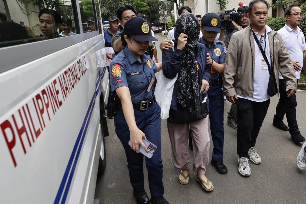 One of eight arrested Department of Public Works and Highways officers is escorted by police in Quezon City, Metro Manila, the Philippines, on Monday. Photo: EPA
