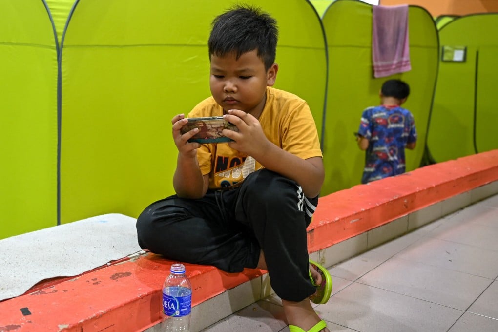 A young boy looks at a mobile phone in Malaysia’s Johor state. The push to bar children from social media follows a string of troubling incidents including viral bullying videos. Photo: AFP
