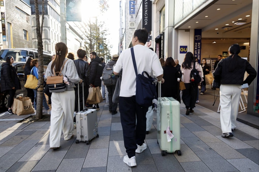 Chinese tourists wheel suitcases through the Ginza shopping district of Tokyo on November 19. China’s Foreign Ministry and its embassy in Japan have advised Chinese citizens against future travel to Japan following recent remarks by Japanese Prime Minister Sanae Takaichi concerning Taiwan. Photo: EPA
