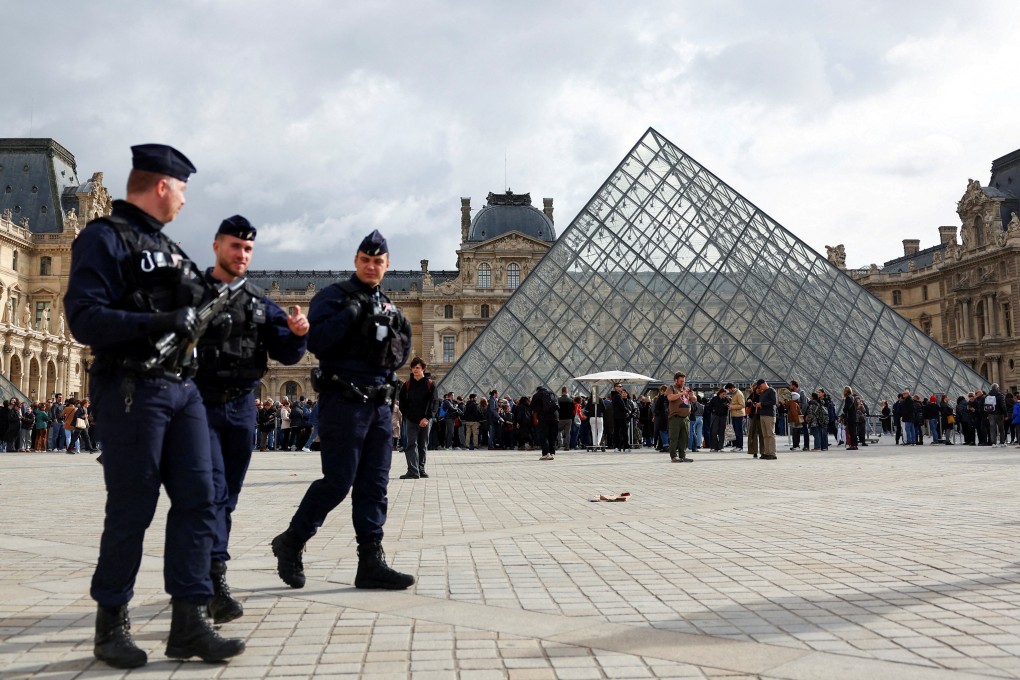 French police walk near the glass Pyramid of the Louvre Museum after authorities arrested suspects in Paris, France last month. Photo: Reuters