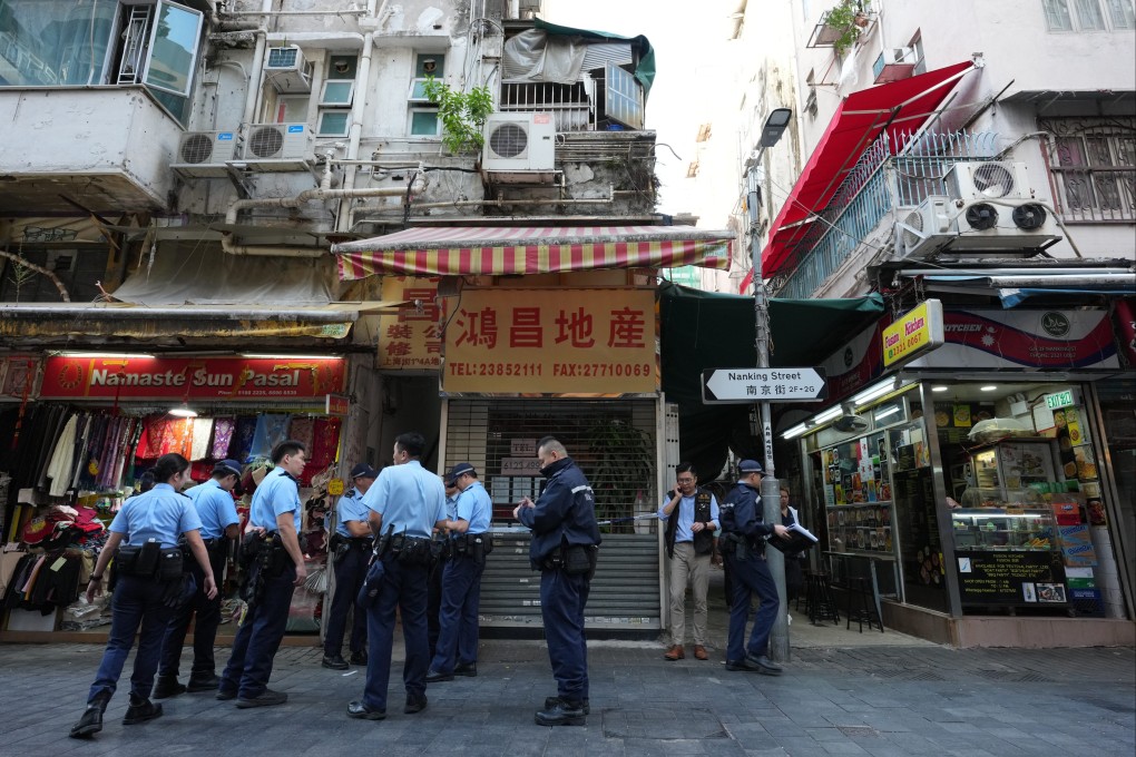 Police officers near the scene of the fatal fire in Yau Ma Tei, where traces of burnt charcoal were found. Photo: Jelly Tse