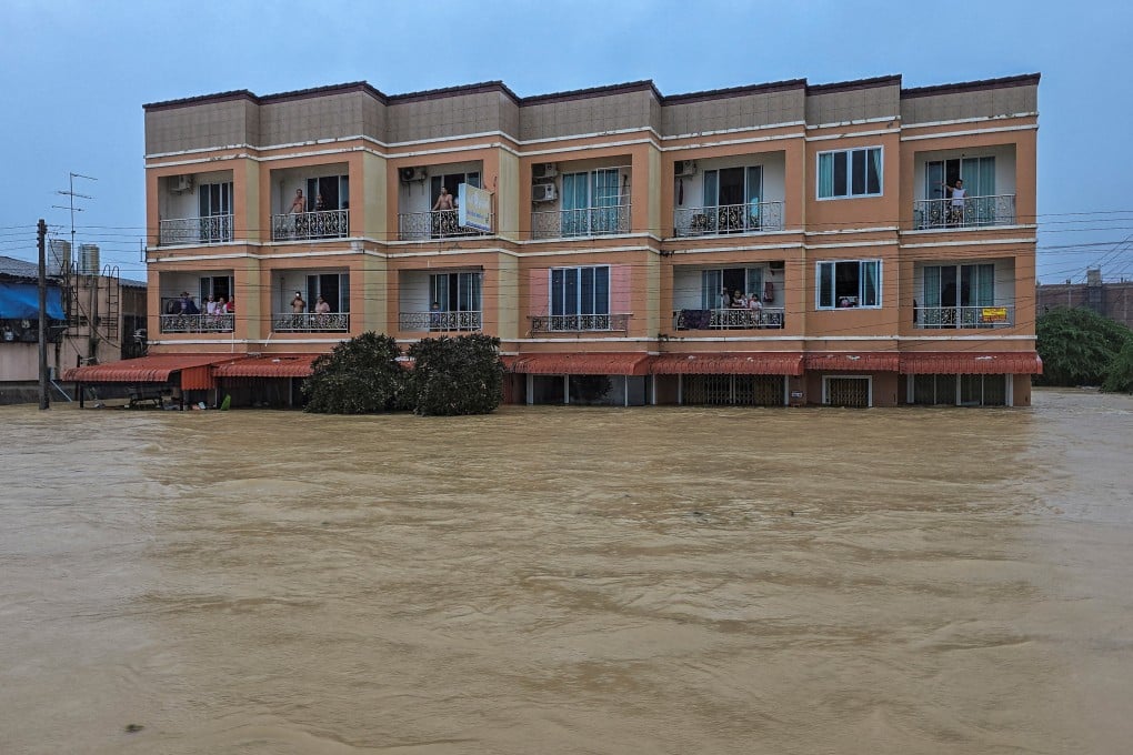 Stranded people look on from their homes which are partially submerged in a flooded area in Hat Yai district, in Thailand’s Songkhla province, on Monday. Photo: Reuters