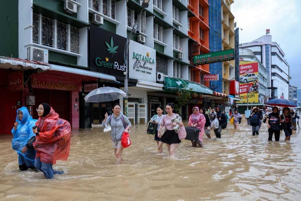Tourists wade through a flooded street in Hat Yai, Thailand’s Songkhla province, on Sunday. Photo: Reuters