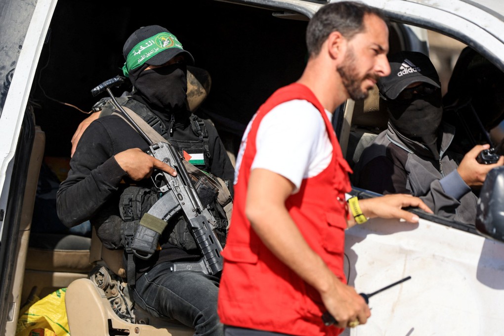 Hamas militants escort members of the Red Cross towards a designated area in Gaza last week. Photo: Reuters