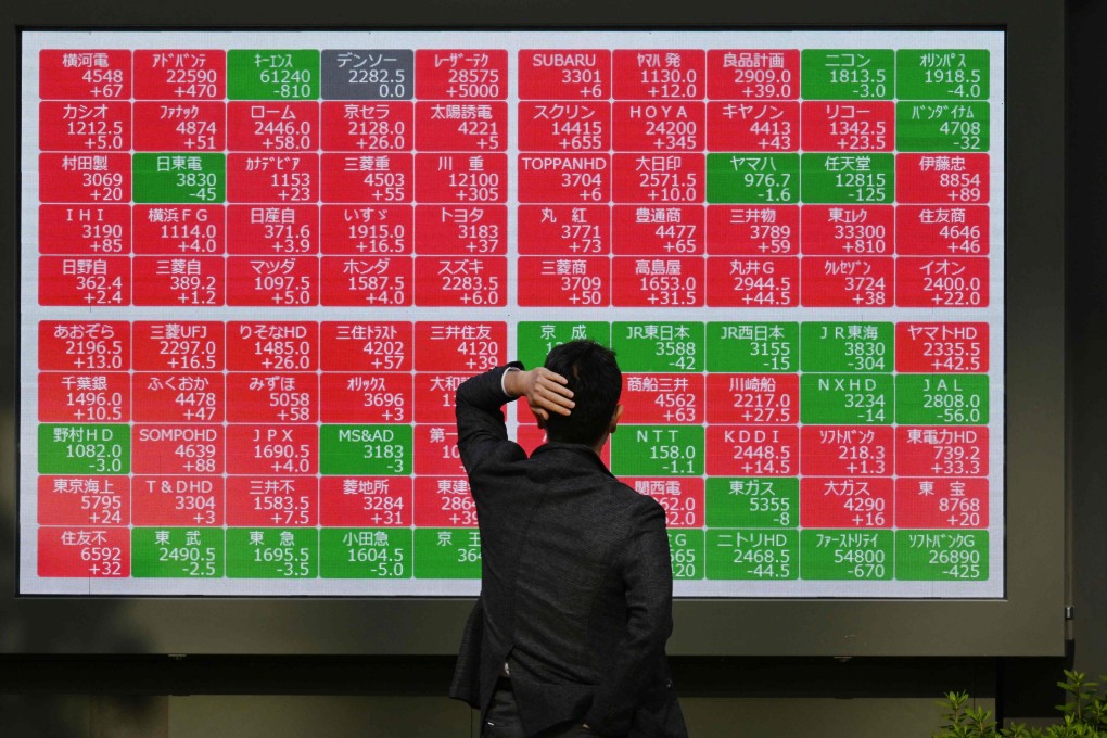 A man looks at a board displaying stock prices on the Tokyo Stock Exchange last month. Photo: AFP