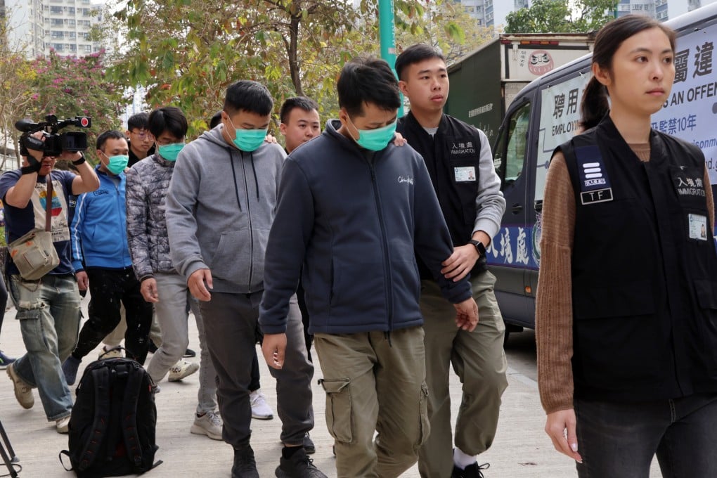 Immigration officers escort suspected illegal workers from a renovation site in Tuen Mun on January 7. Photo: Jelly Tse
