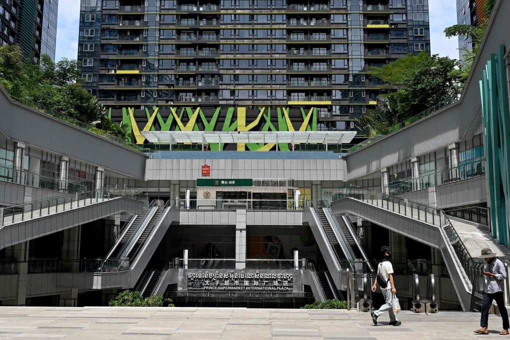People walk past the Prince International Plaza in Phnom Penh in October. On Thursday, South Korea sanctioned 15 individuals and 132 entities, including Prince Group, for online crimes. Photo: AFP