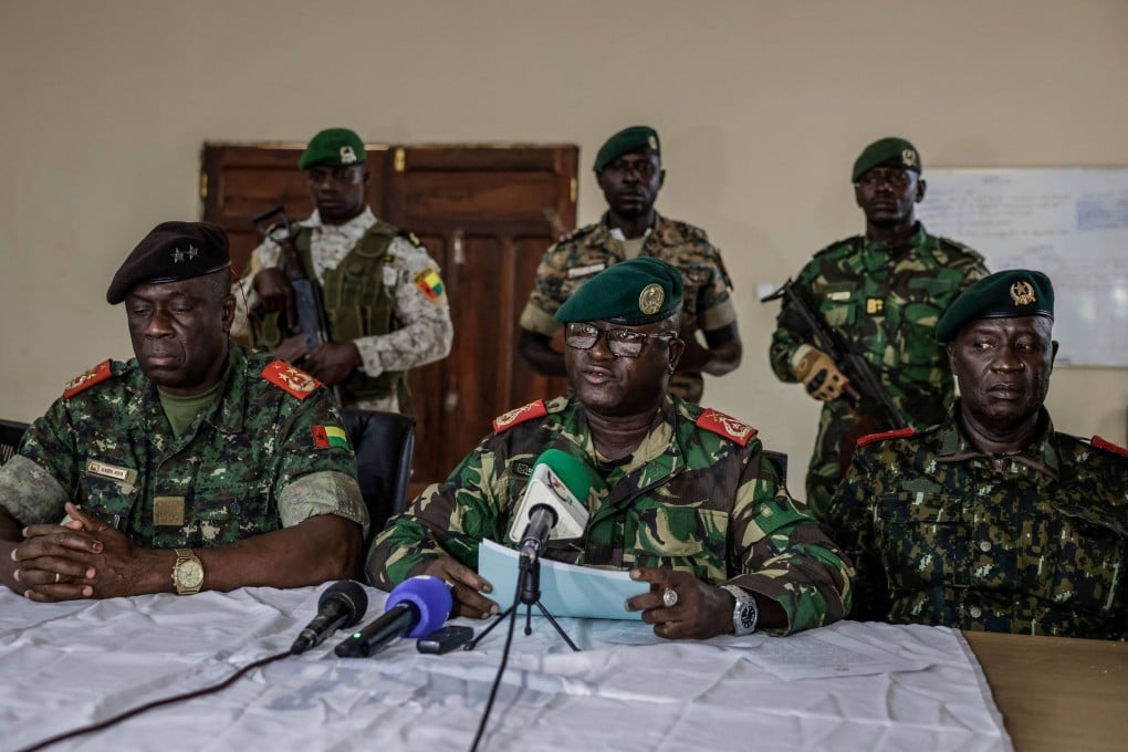 Brigadier General Dinis N’Tchama, flanked by others during a televised statement. Photo: AFP