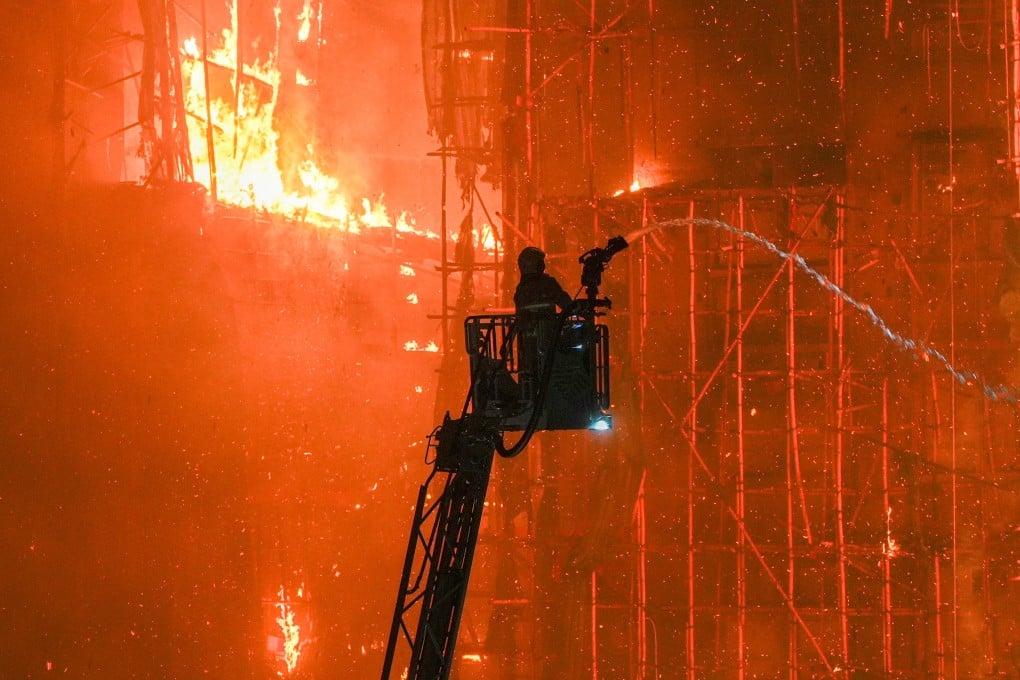 A firefighter shoots water at a fire at Wang Fuk Court in Tai Po, Hong Kong, on November 26, 2025. All eight buildings on the estate had been covered in bamboo scaffolding amid ongoing renovation works. Photo: Eugene Lee