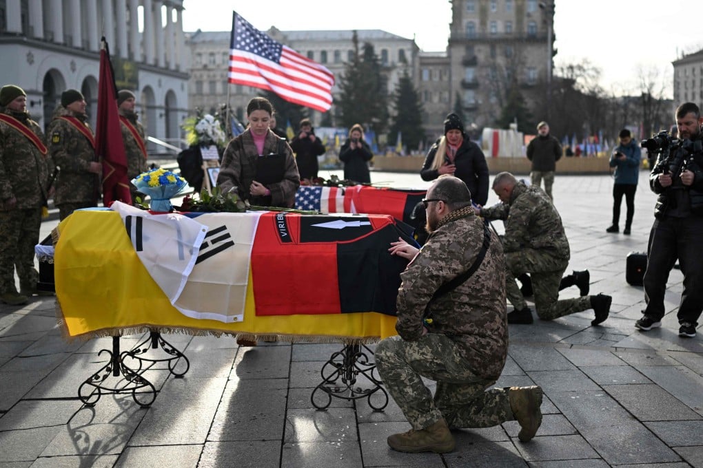 Servicemen pay tribute next to the coffins of slain South Korean and American volunteer soldiers in Kyiv on Tuesday, amid the Russian invasion of Ukraine. Photo: AFP