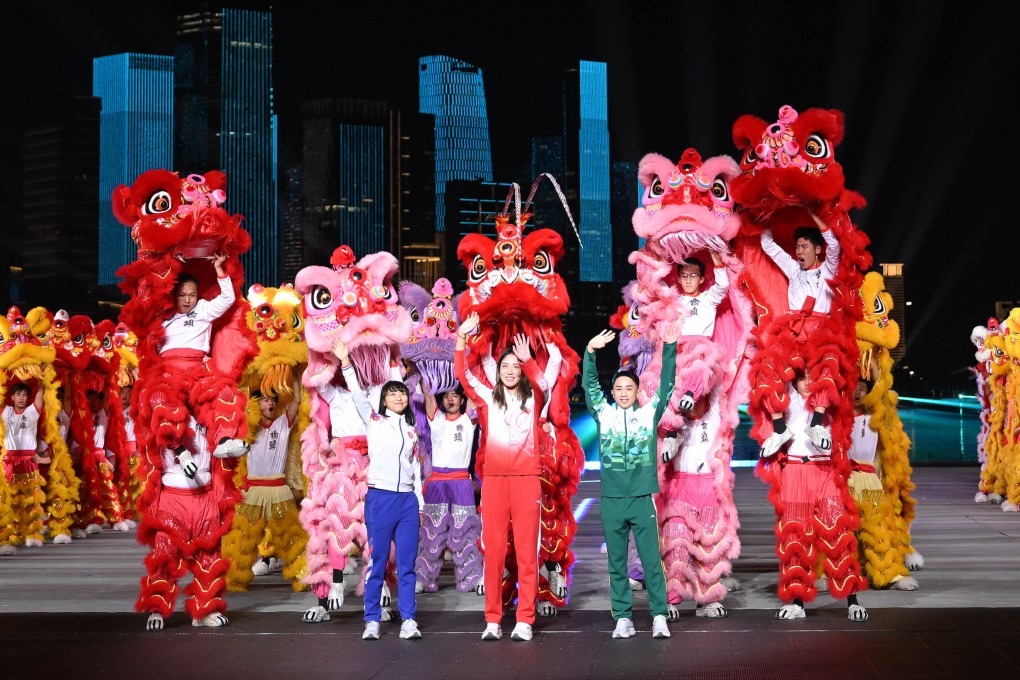 Wang Xinyu (centre) of Guangdong, Ceci Lee Sze-wing (left) of Hong Kong and Kuok Kin Hang of Macau wave as artists perform during the closing ceremony of the 15th National Games in Shenzhen on November 21. Photo: Xinhua