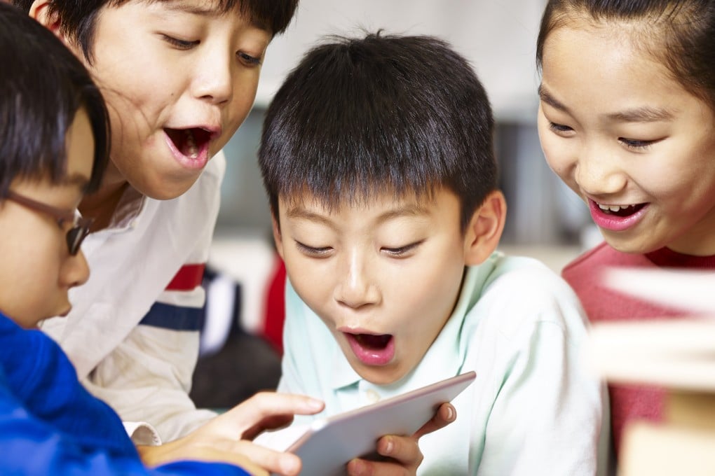 A group of children playing on a tablet. A recent trend in Singapore is of parents sharing videos of their children online. Photo: Shutterstock