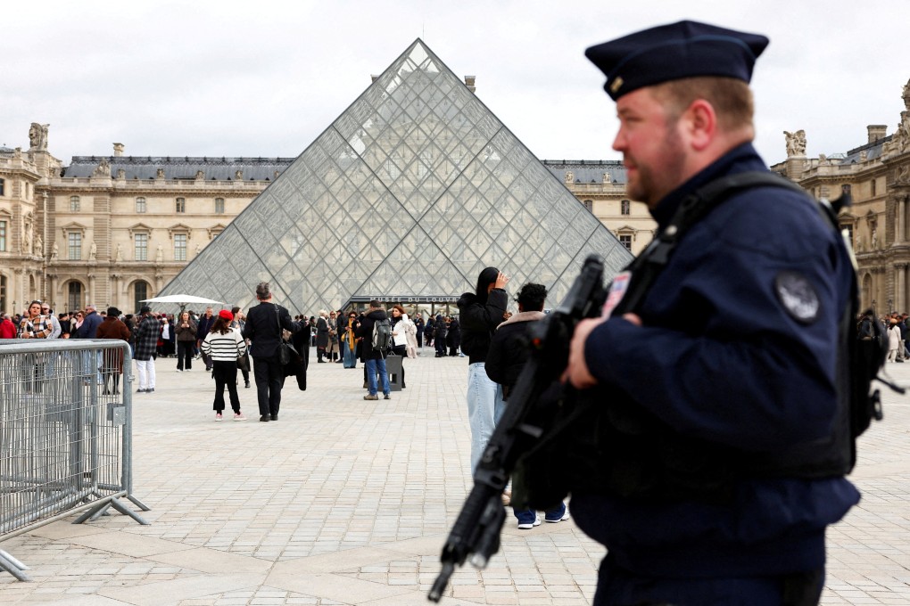 A French riot police officer patrols near the glass Pyramid of the Louvre Museum last month, after French police arrested suspects allegedly involved in a jewellery heist. Photo: Reuters