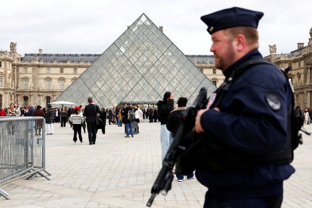 A French riot police officer patrols near the glass Pyramid of the Louvre Museum last month, after French police arrested suspects allegedly involved in a jewellery heist. Photo: Reuters