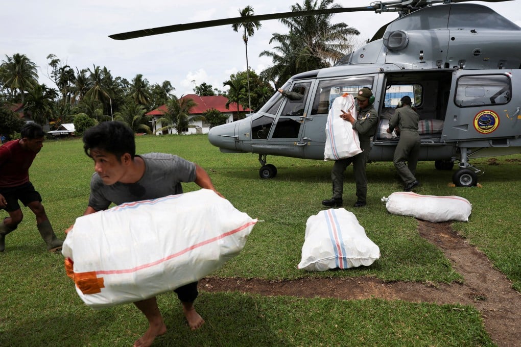 A man moves relief supplies delivered by a Navy helicopter in an area affected by deadly flash floods in Palembayan, Agam regency, West Sumatra province, Indonesia, on Saturday. Photo: Reuters