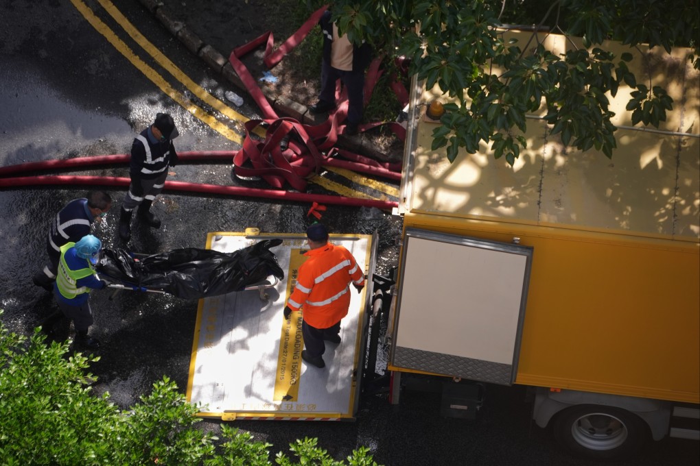 A dead body is lifted into a vehicle outside Wang Fuk Court in Tai Po. Photo: Elson Li