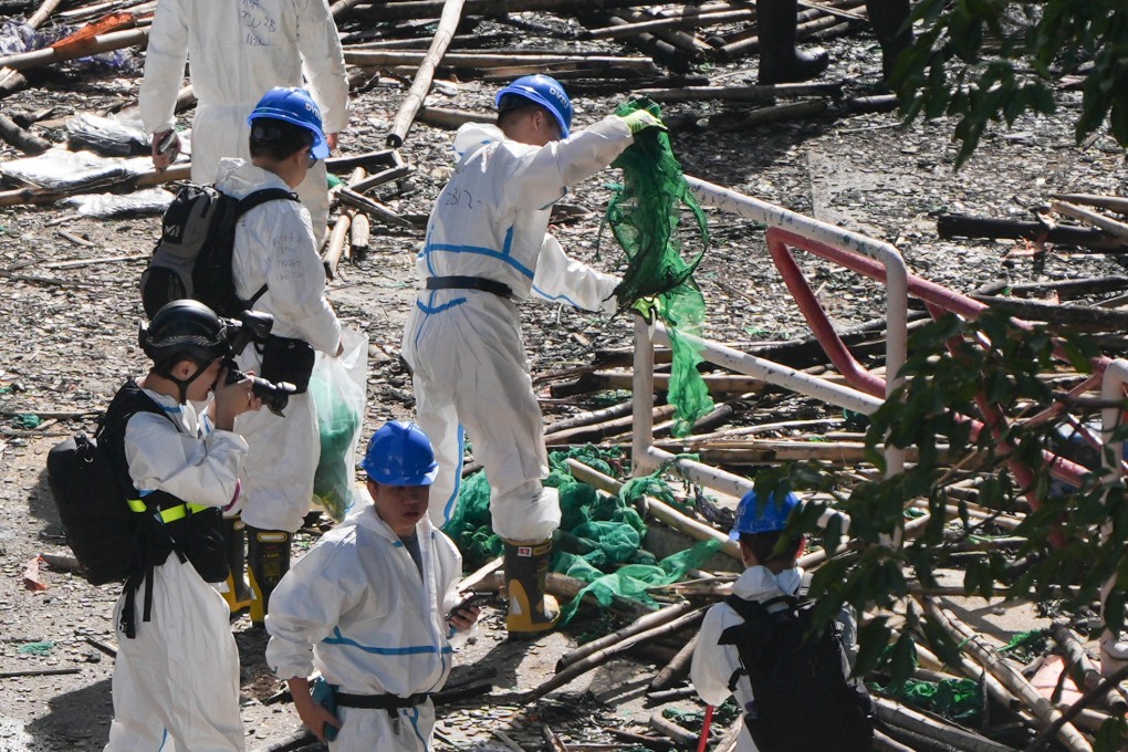 DVIU squad members search for evidence at the scene of the Tai Po fire. Photo: Eugene Lee