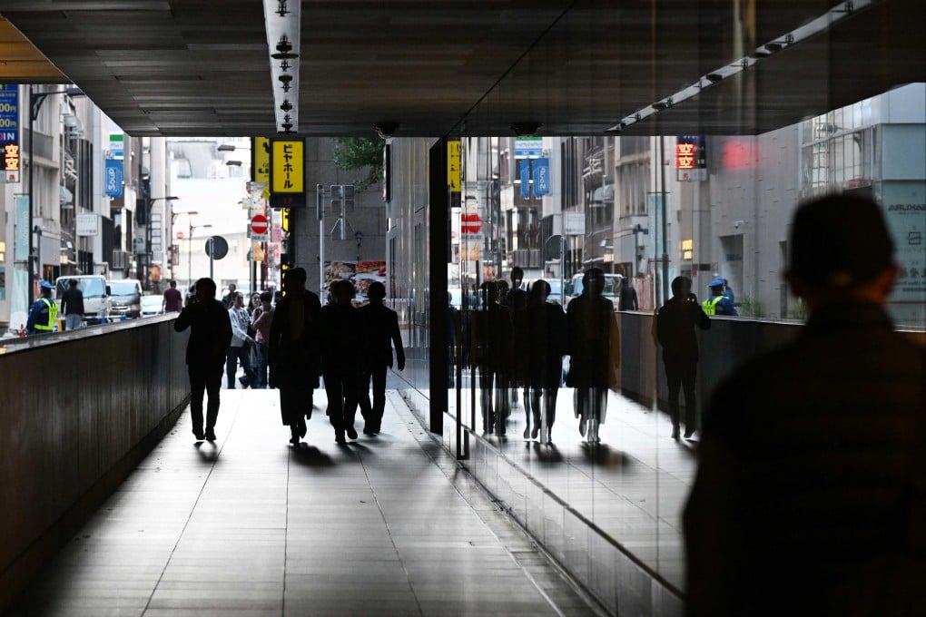 People walk between buildings in Tokyo on November 17. A diplomatic feud between China and Japan is having economic implications. Photo: AFP