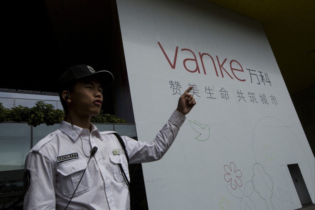 A security guard gestures in front of Vanke’s headquarters in Shenzhen. Vanke has proposed delaying repayment on a yuan-denominated bond for the first time, causing the prices of some its dollar-denominated bonds to fall into distressed territory. Photo: Reuters